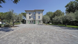 A building with a symmetrical facade, multiple windows, and a central entrance. - Villa Caterina 10 - LOC (Desenzano del Garda)