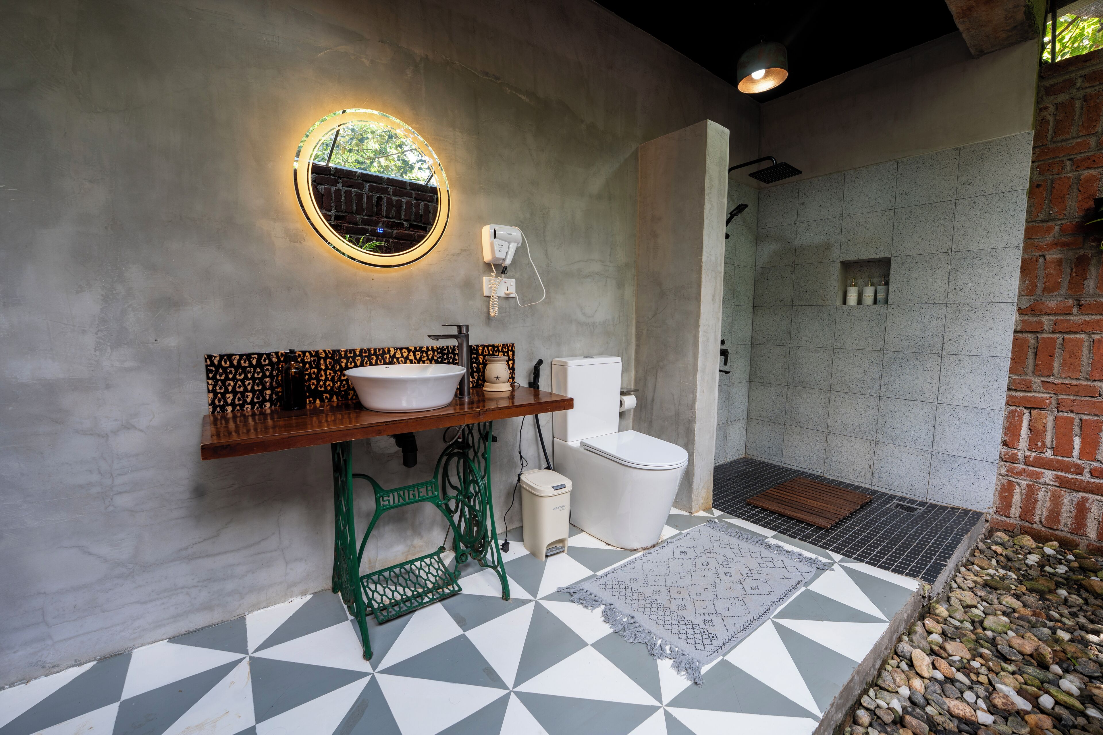 Une salle de bain comprenant un lavabo, des toilettes et un espace douche.