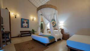 A bedroom with a bed, bedside table, lamp, and a painting on the wall.