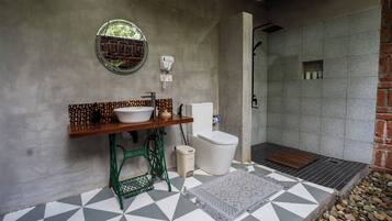 Une salle de bain avec un lavabo, des toilettes et une douche.