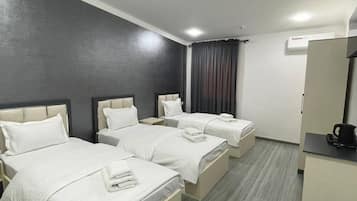 Habitación triple familiar, vistas al patio | Escritorio y espacio para trabajar con un portátil