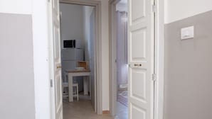 A narrow hallway with a door leading to a kitchen area. - Myia 1A in Siracusa With 1 Bedrooms and 1 Bathrooms (Syracuse)