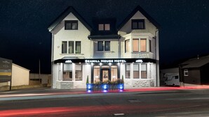 A two-story hotel with a prominent sign reading "SEAMILL HOUSE HOTEL".