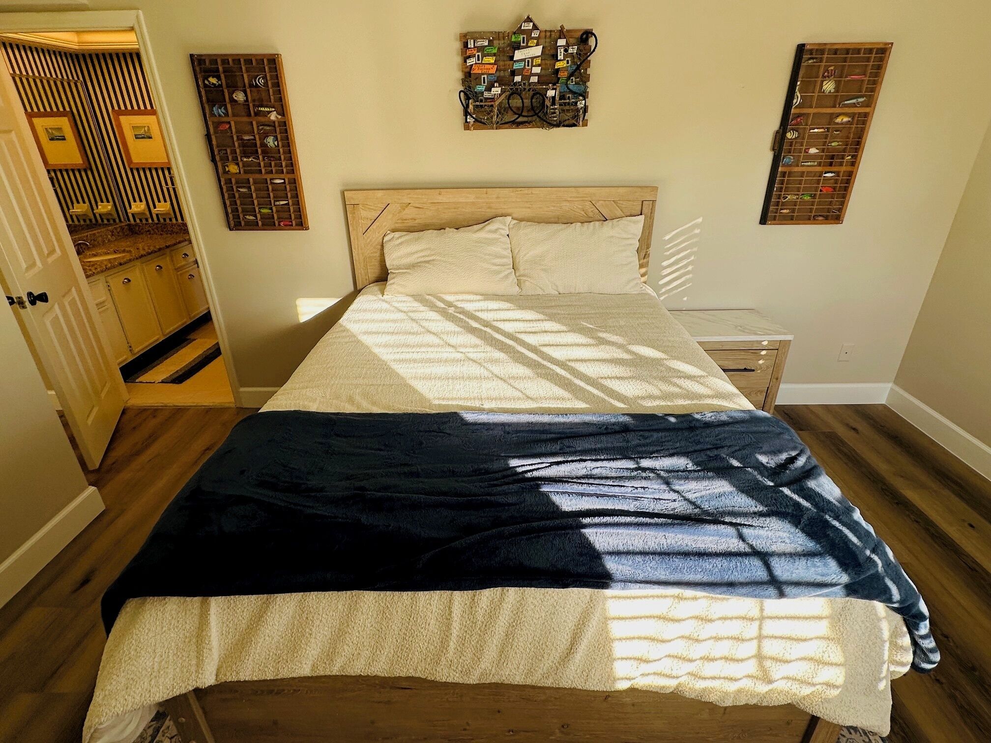Une chambre à coucher avec un lit en bois, une tête de lit, une table de chevet et un luminaire fixé au mur.