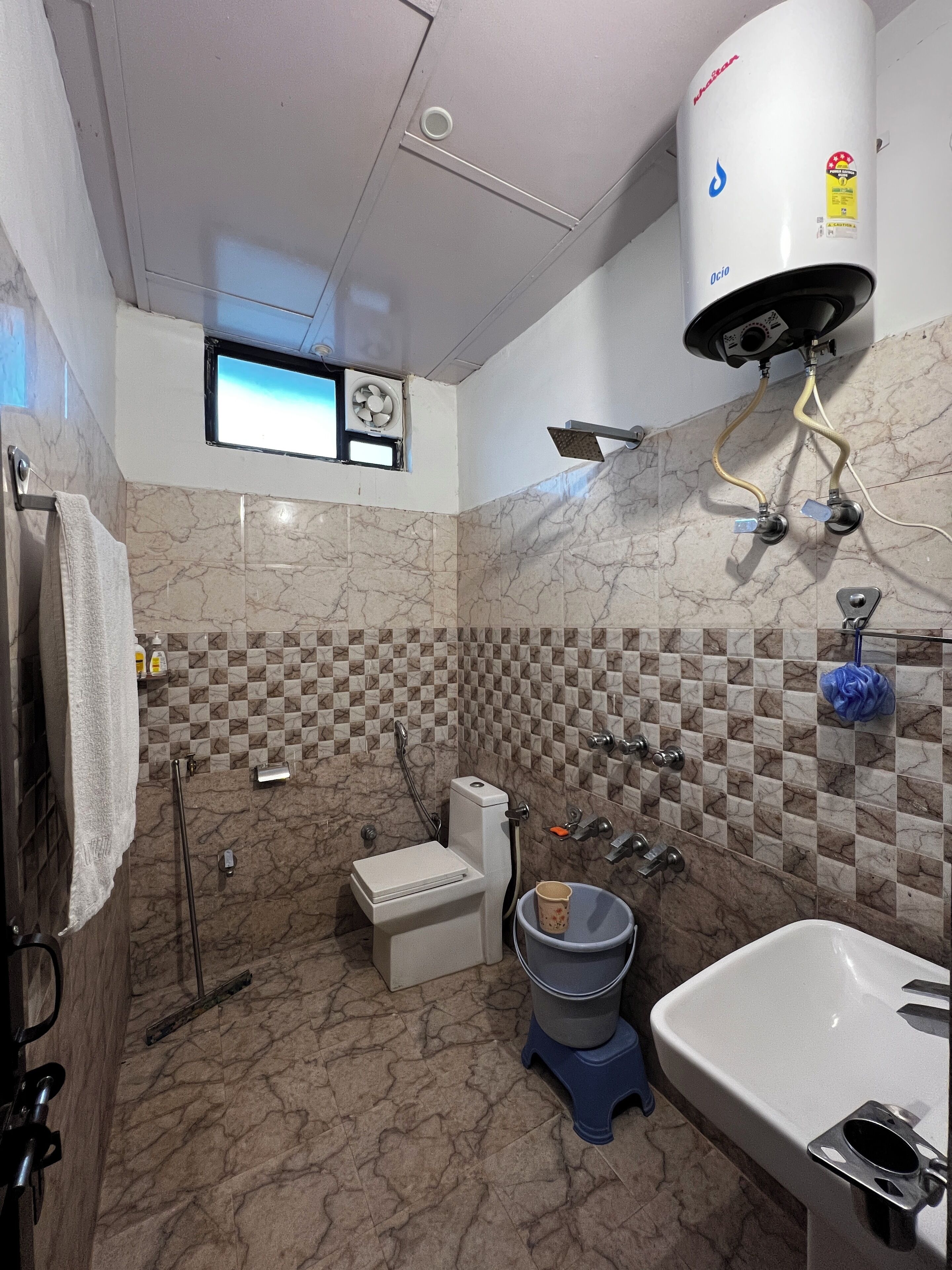 A bathroom with a toilet, bidet, sink, and a water heater.