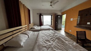A room with three beds, a ceiling fan, and a view of the outside. - Uday Homestay (Baijnath)