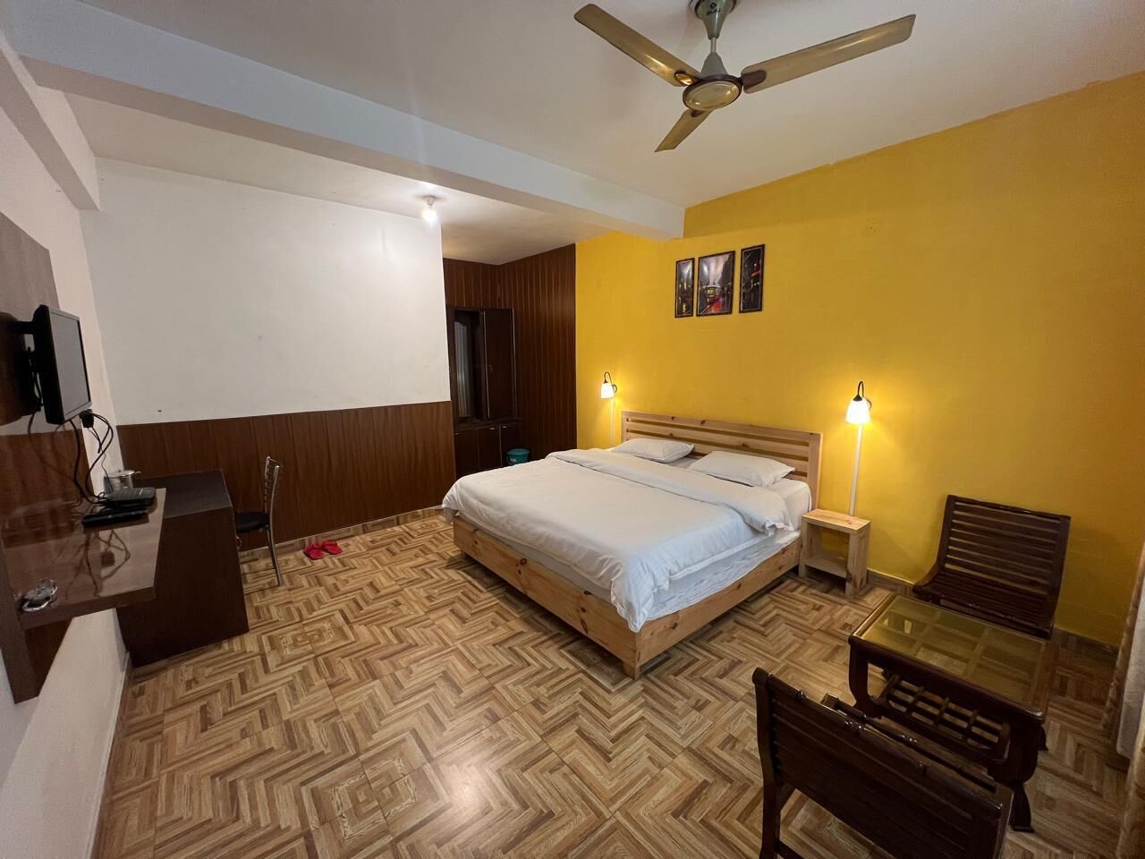 A bedroom with a bed, bedside tables, a desk, and a chair.