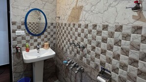A bathroom with a sink, mirror, and shower. - Uday Homestay (Baijnath)