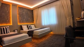 Een hotelkamer met twee bedden, een bureau en een stoel.