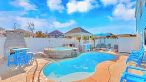 A backyard with a swimming pool, a hot tub, and outdoor seating.