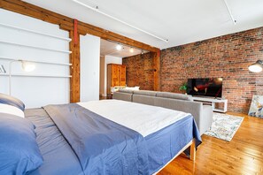 Relax in this stylish living room with a large bed, comfortable sofa, and flat-screen TV.