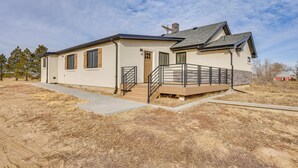Een gelijkvloers huis met een veranda, een kleine trap en een garage.