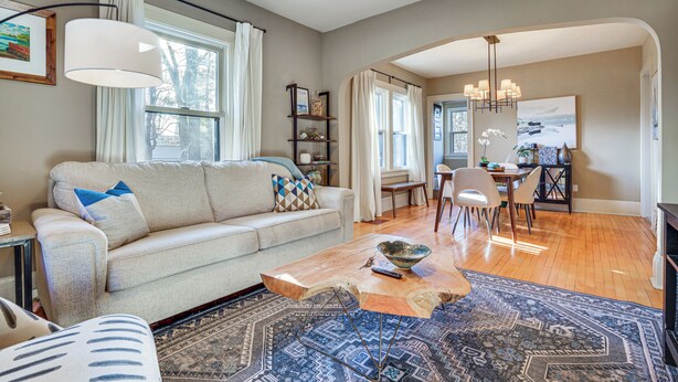 A spacious living room with a sofa, coffee table, and dining area. - Walk to Beach + Lake Nokomis: Minneapolis Home! (Minneapolis)