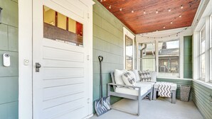 A porch with a white bench, a small table, and a rug. - Walk to Beach + Lake Nokomis: Minneapolis Home! (Minneapolis)