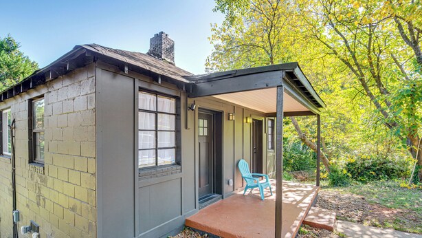 A small, single-story house with a covered porch, a brick exterior, and a chimney. - Studio Apartment Near East Atlanta Village (Atlanta)