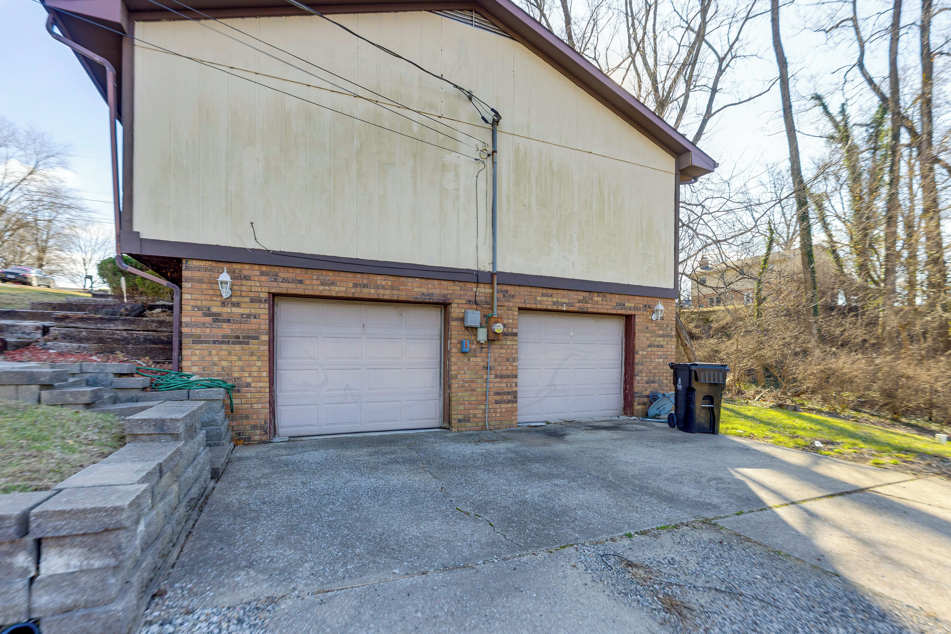 A two-story building with a garage and a brick facade.