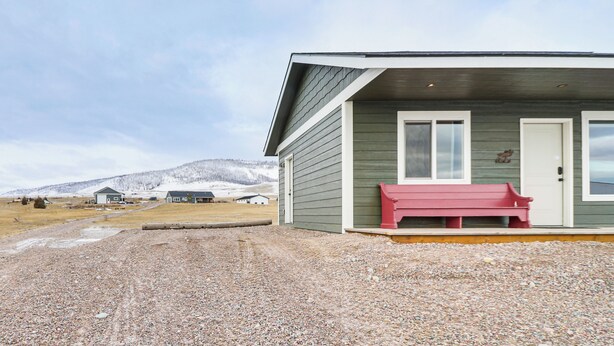 A single-story building with a gravel driveway and a red bench outside. - Starry Skies & Mtn Views: Family Retreat in Elmo (Elmo)