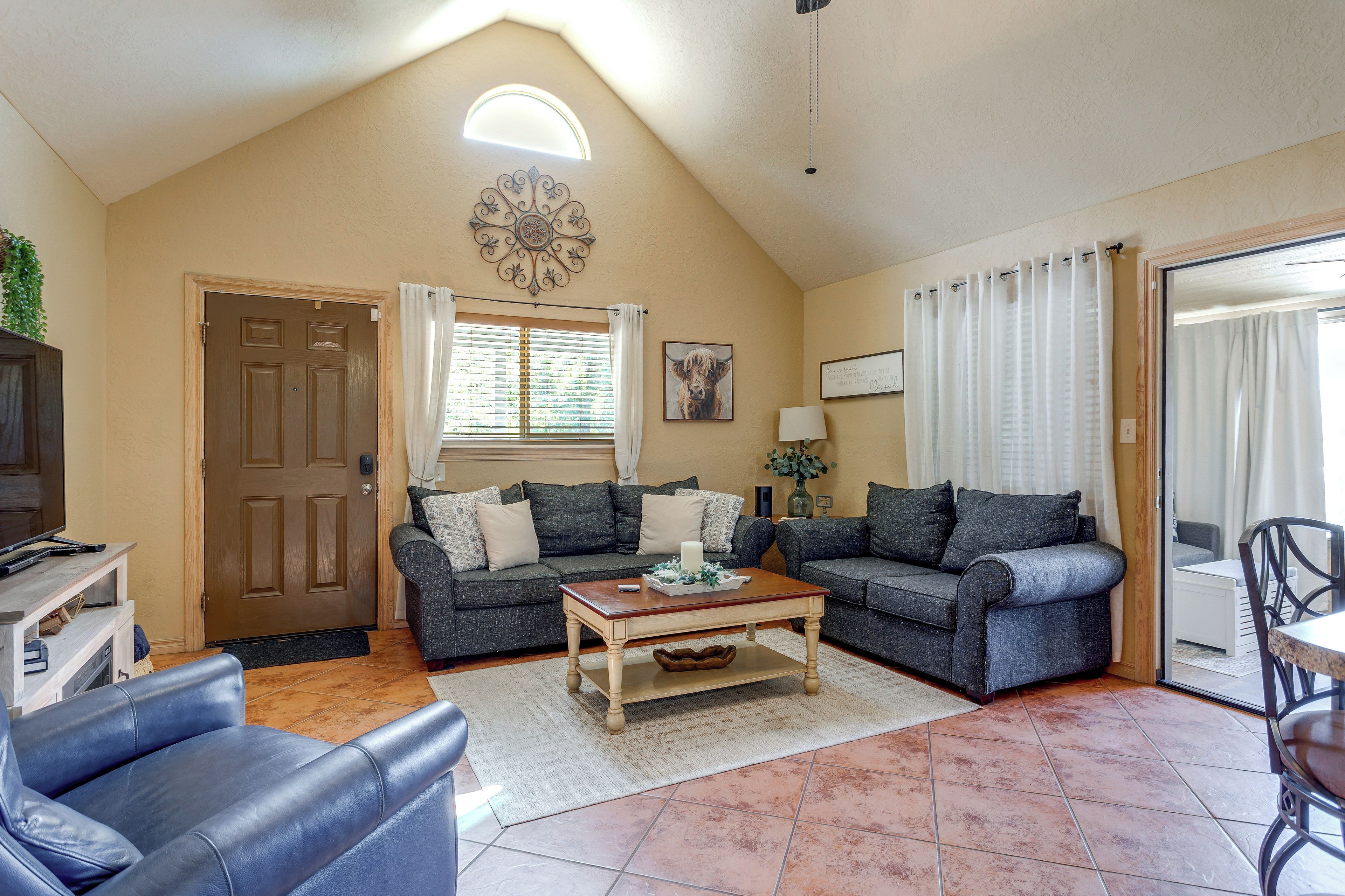 A living room with two sofas, a coffee table, and a television on a wooden stand.