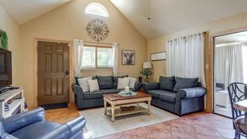 A living room with two sofas, a coffee table, and a television on a wooden stand.