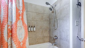A bathroom with a shower, a bathtub, and three bottles of toiletries. - 1/2 Mi to Lake Lawtonka: Mtn-view Haven! (Medicine Park)