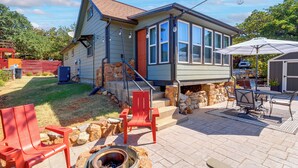 A house with a stone foundation, a red door, and a patio with outdoor furniture. - 1/2 Mi to Lake Lawtonka: Mtn-view Haven! (Medicine Park)