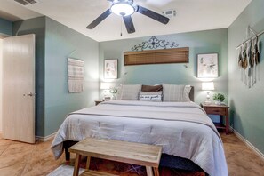 A bedroom with a bed, bedside tables, a ceiling fan, and wall decorations. - 1/2 Mi to Lake Lawtonka: Mtn-view Haven! (Medicine Park)