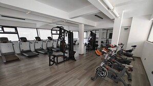 Un gimnasio amplio con cintas de correr, máquinas de pesas y bicicletas estáticas.