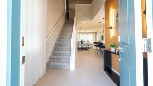 Un escalier menant à une salle à manger, avec une cuisine en arrière-plan.