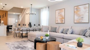 Un salon moderne avec un canapé, une table basse et un coin repas.