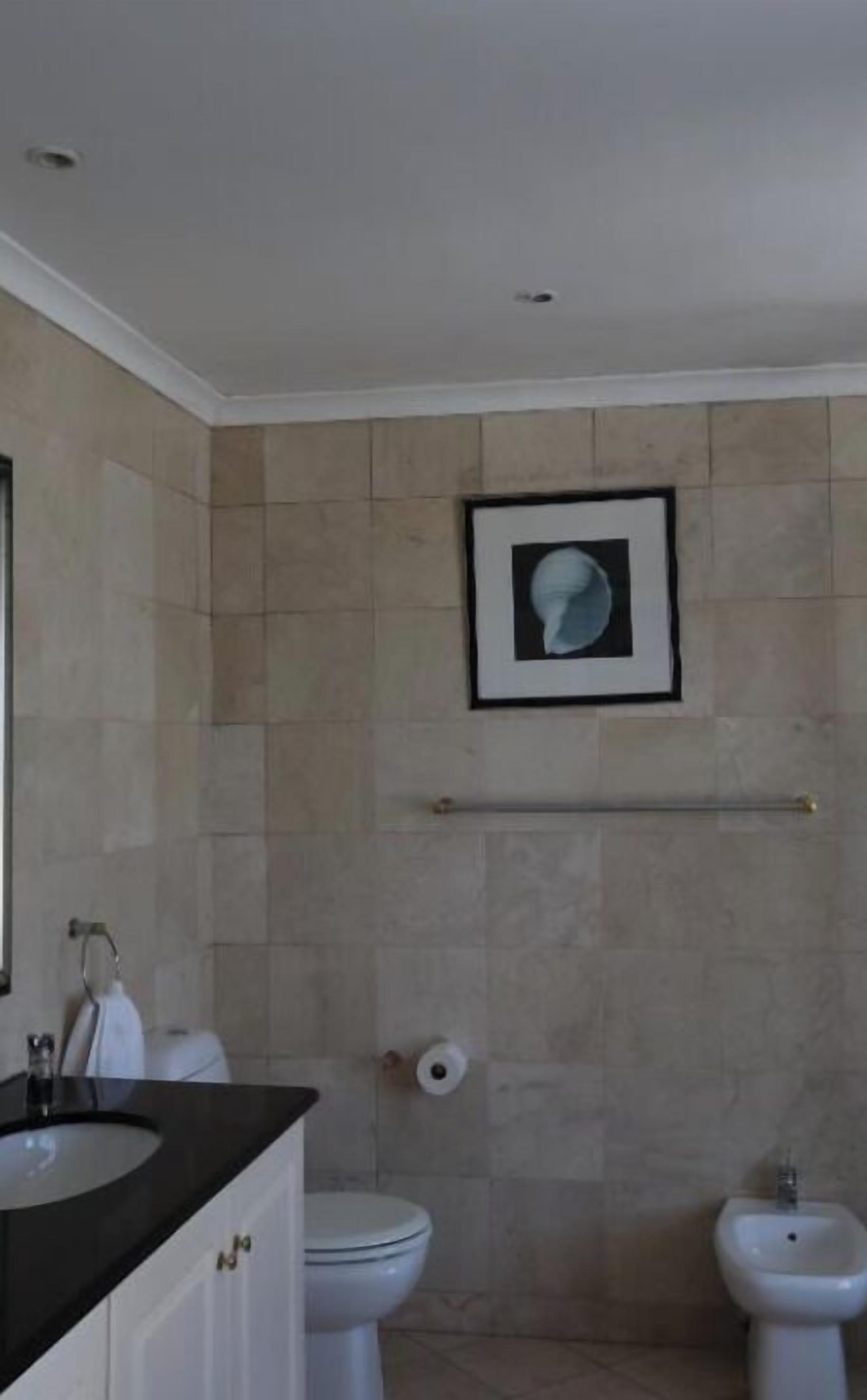 A bathroom with a toilet, bidet, and sink.