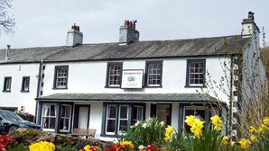 A two-story building with a sign reading "Woolpack Inn." - Woolpack Inn (Holmrook)
