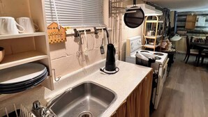 A compact kitchen with a sink, stove, and various utensils. - Riverside suite on York River in town free parking 

 (Bancroft)