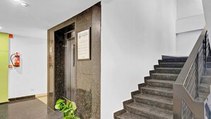 Ein modernes Interieur mit einer Marmortreppe, einem Feuerlöscher und einem gerahmten Schild an der Wand.