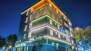 Ein mehrstöckiges Hotel mit modernem Design, Balkone und einer gut sichtbaren Beschilderung.