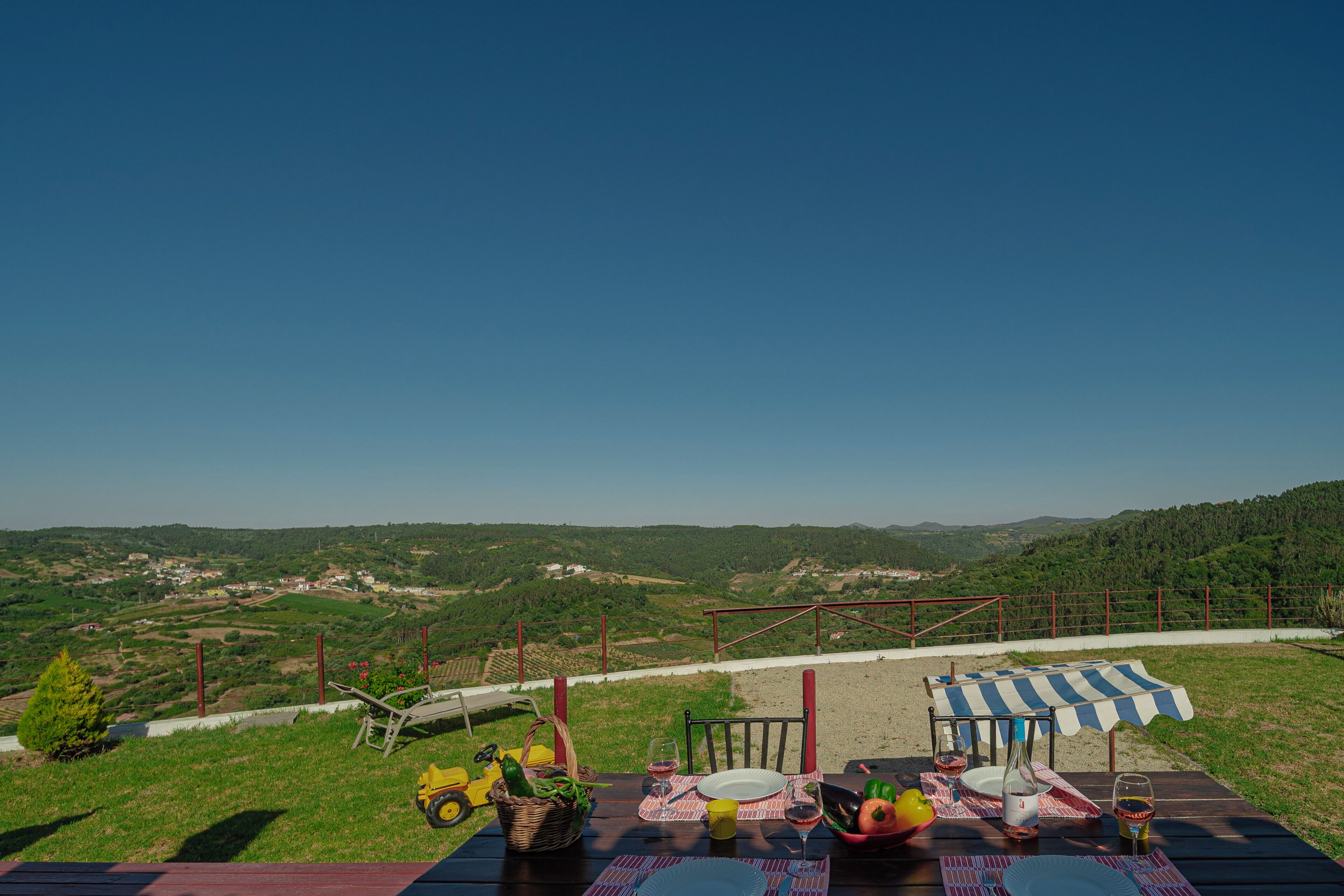 A table set outdoors with a view of a hilly landscape.