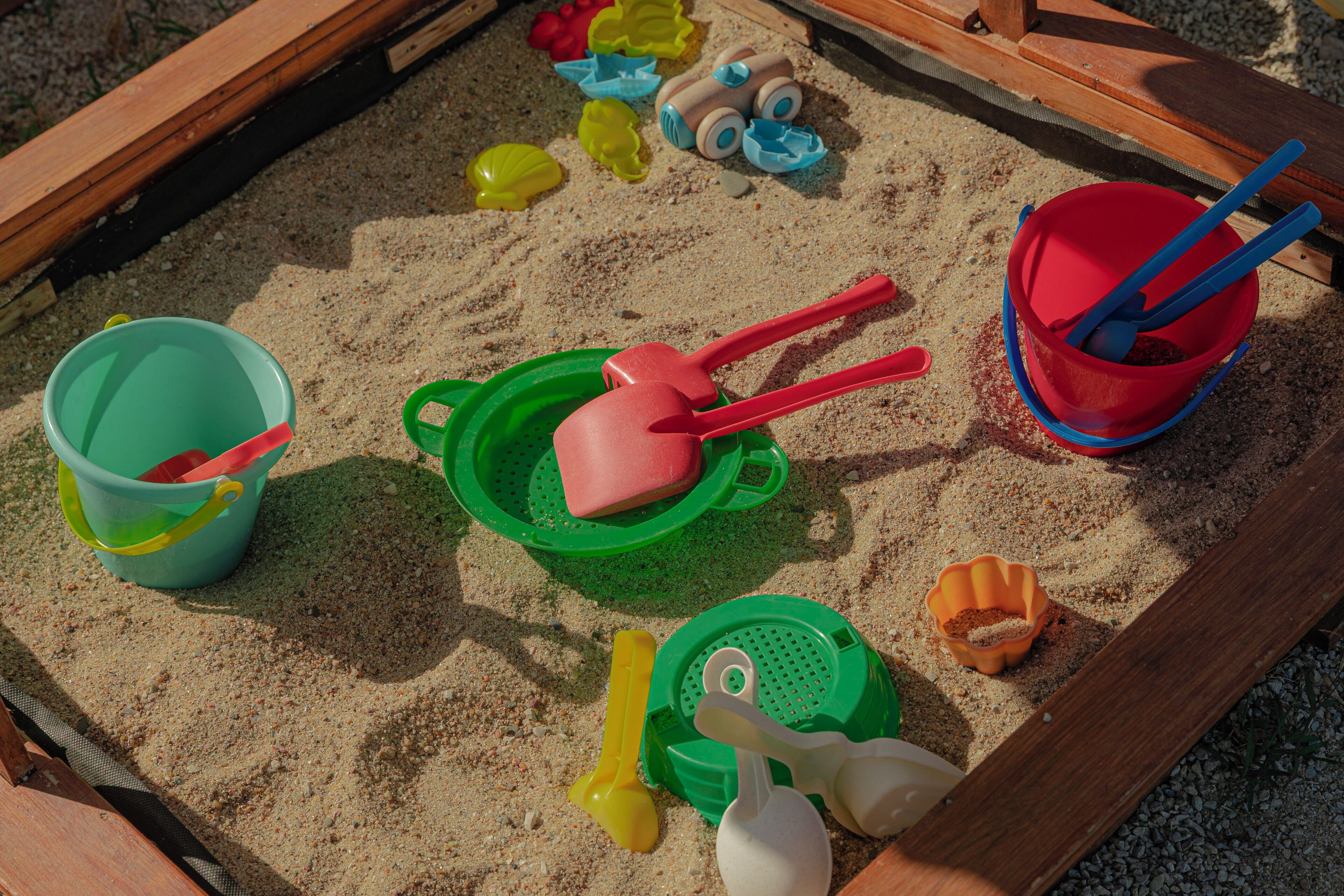 A sandbox with various toys and sand toys.