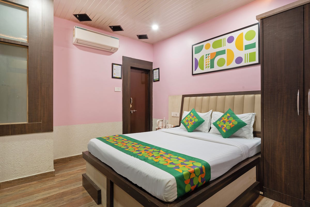 Habitación de hotel con cama, armario, puerta y aire acondicionado instalado en la pared.