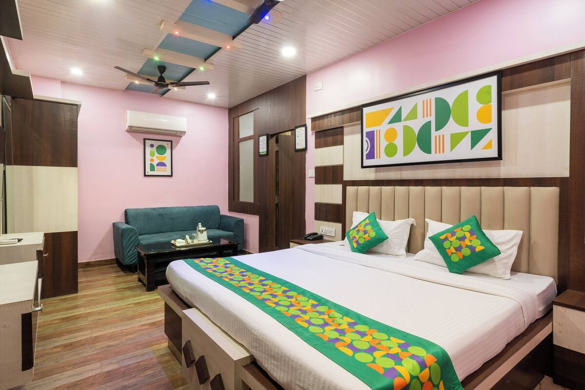 Una habitación de hotel con cama, sofá, escritorio y ventilador de techo.