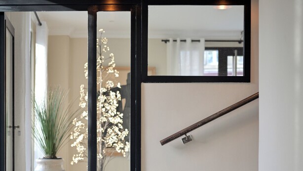 Een modern interieur met een trap, een potplant en een decoratieve lamp.