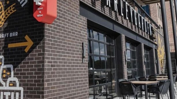 Un bâtiment en briques avec une enseigne indiquant « Barley & Garden » et une autre enseigne, « Craft Bar », pointant vers la gauche.
