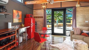 Una cocina moderna con un refrigerador rojo, una mesa de comedor con sillas rojas y un ventanal con vistas al exterior.