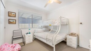 A bunk bed room with a desk, chair, and two framed pictures on the wall. - Mirrabooka - Charming 2-bedroom holiday house (Lake Cathie)