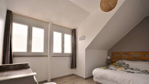 A bedroom with a bed, a desk, and a window. - Renovated house located 5 minutes from the beach and playground, close to shops. (Le Crotoy)