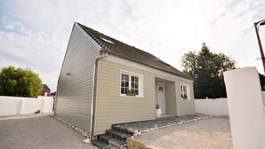 A single-story house with a sloped roof, a front door, and a small porch area. - Renovated house located 5 minutes from the beach and playground, close to shops. (Le Crotoy)