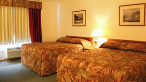 A hotel room with two beds, a window with curtains, a wall-mounted lamp, and two framed pictures. - Western Budget Plus Killam Krossing (Killam)