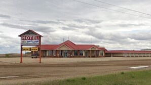 A hotel with a red roof and a sign indicating it is now open. - Western Budget Plus Killam Krossing (Killam)