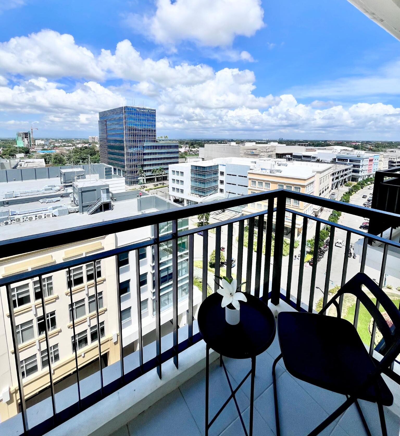 A balcony with a view of a cityscape, including a prominent building labeled 'BIRDMORE TOWER'.