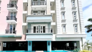 Um hotel com piscina, várias varandas e um design arquitetônico moderno.