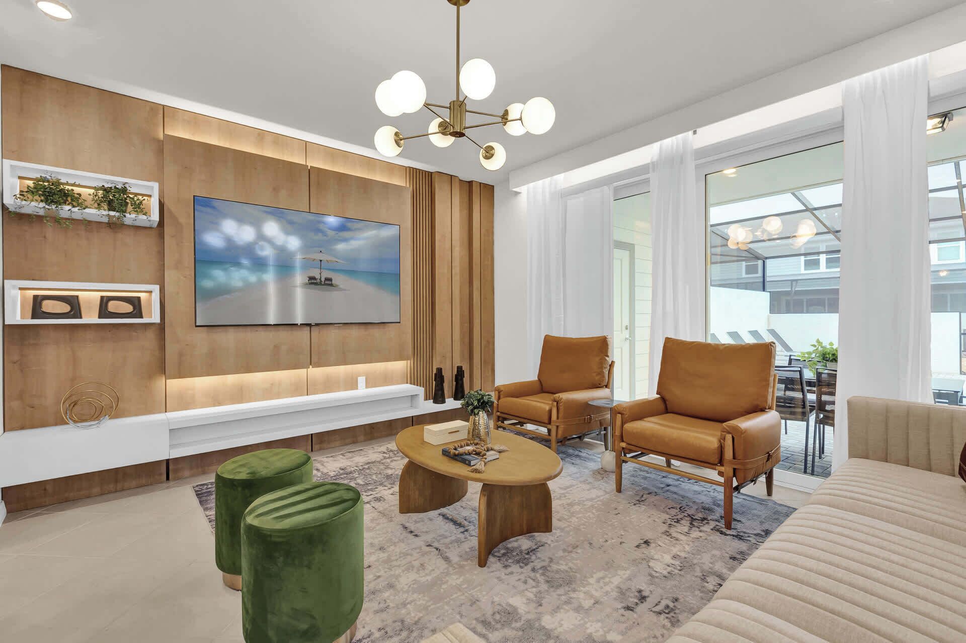 Een moderne woonkamer met een grote flatscreen-tv, leren fauteuils, een salontafel en een bank.