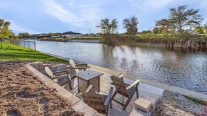 A riverside patio with outdoor seating and a view of the water. - Waterfront Private Pool Home With Nearby Beaches (Cape Coral)